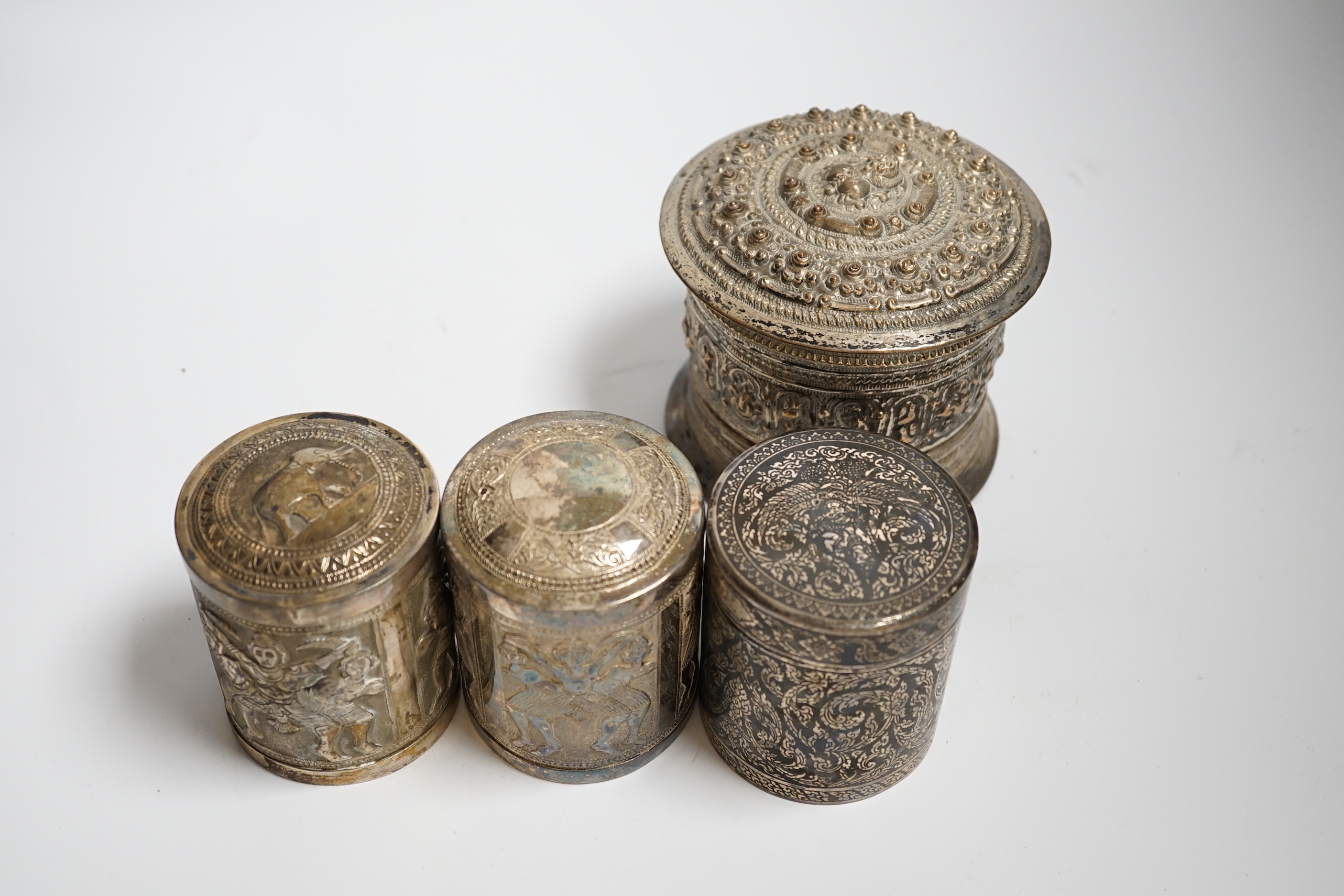 Three Burmese white metal boxes, and a Thai silver and niello work box, tallest 11cm